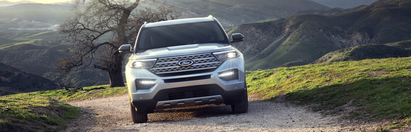 A silver 2020 Ford Explorer driving up a gravel road on a mountain