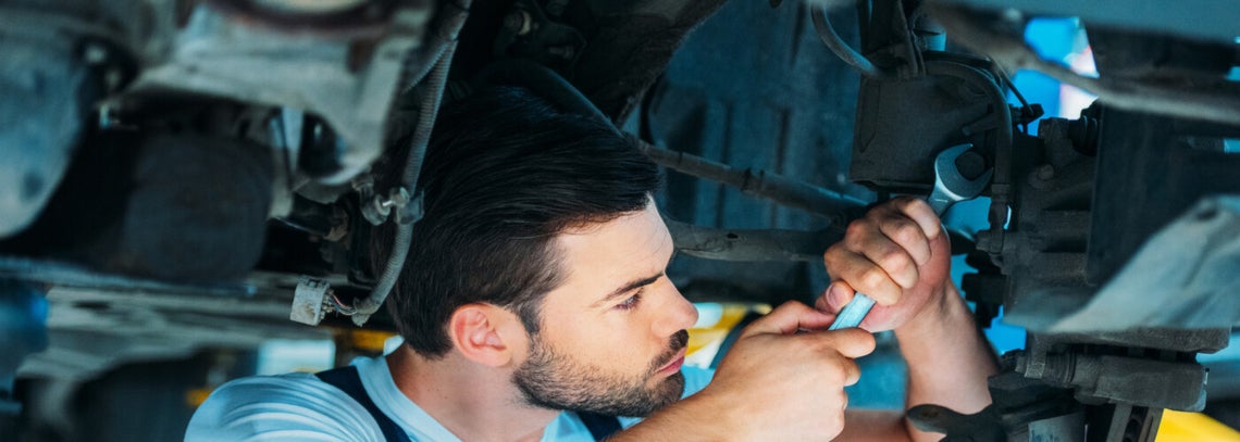 Mechanic Fixing Under Car
