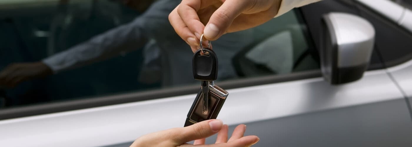 Salesperson handing car keys to customer