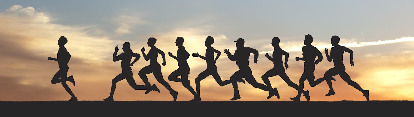 Silhouette of marathon runners at sunset